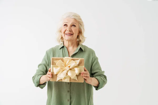 Серый Пожилая Женщина Улыбается Показывая Подарочную Коробку Камеру Изолированы Белом — стоковое фото