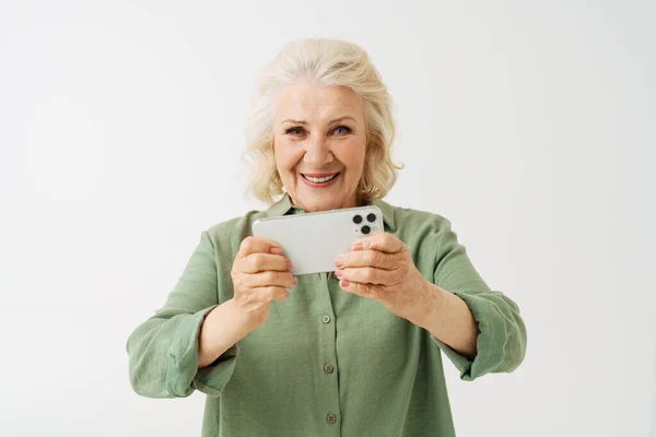 Серый Пожилая Женщина Улыбается Играя Онлайн Игру Мобильном Телефоне Изолированы — стоковое фото