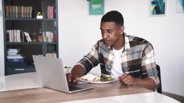 Happy African Brunet Mann Beim Frühstück Und Blick Auf Laptop — Stockvideo
