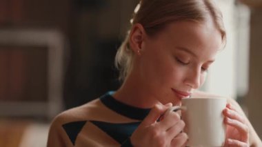 Kafede kahve içen güzel sarışın kadın.