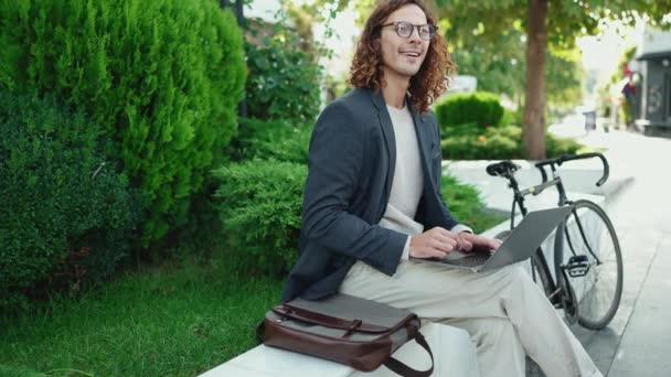 Positieve Krullenbol Man Dragen Jas Werken Laptop Rond Kijken Buiten — Stockvideo