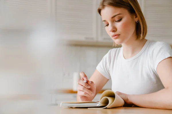 Mujer Joven Sonriente Escribiendo Diario Mientras Está Sentada Mesa Cocina —  Fotos de Stock
