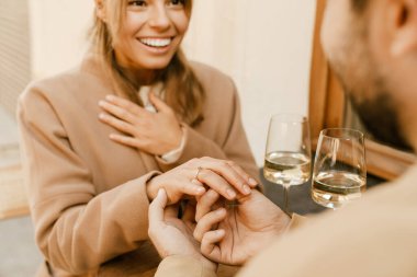 Beyaz adam dışarıda, kafede heyecanlı kız arkadaşına evlenme teklif ediyor.