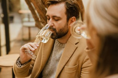 Kafede buluşurken şarap içen beyaz romantik çift.