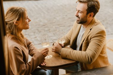 Kafede buluşurken şarap içen beyaz romantik çift.