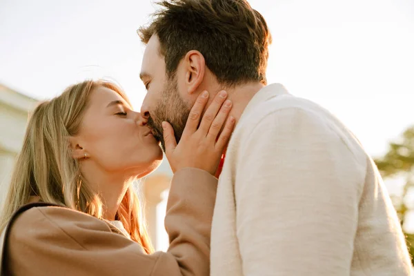 白いロマンチックなカップル接吻と抱擁しながら公園で屋外 — ストック写真
