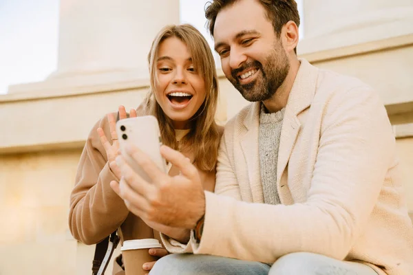 Casal Romântico Branco Usando Celular Rindo Durante Data Livre — Fotografia de Stock