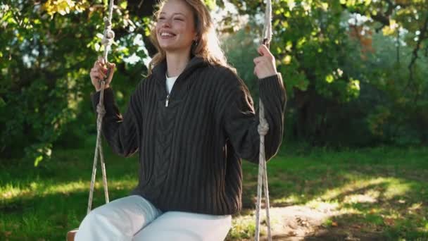 Sonriente Mujer Rubia Balancea Columpio Soleado Parque — Vídeos de Stock