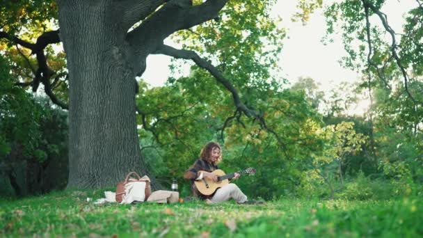 Homem Cabelos Encaracolados Tocando Guitarra Cantando Cobertor Piquenique Parque — Vídeo de Stock