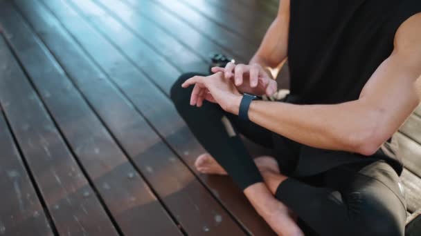 Sporcu Dışarıda Yoga Minderinde Otururken Saatine Bakıp Meditasyon Yapıyor — Stok video