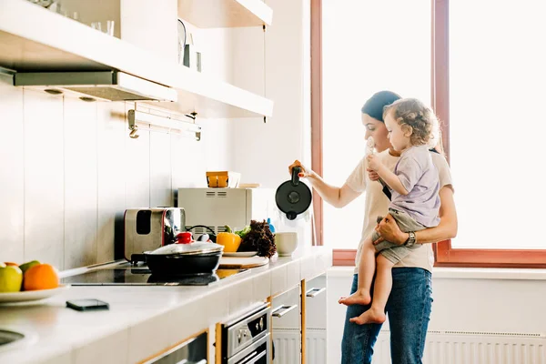 Leende Ung Mor Matlagning Frukost Köket Hemma Bär Sin Son — Stockfoto