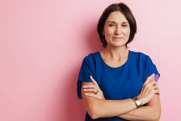 Mature Woman Smiling While Posing Arms Crossed Isolated Pink Background — Stock Photo, Image