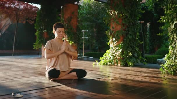 Сконцентрированная Короткошерстная Женщина Медитирует Сидя Позе Лотоса Открытом Воздухе — стоковое видео
