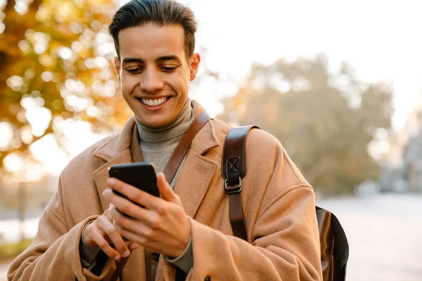 Young Man Wearing Coat Using Mobile Phone While Walking Park — Stock Photo, Image
