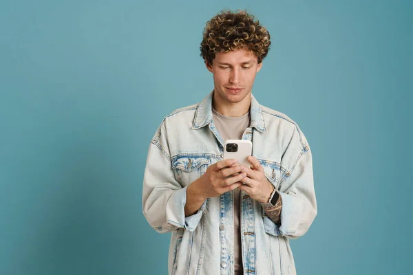 Joven Hombre Rizado Con Chaqueta Mezclilla Usando Teléfono Móvil Aislado — Foto de Stock