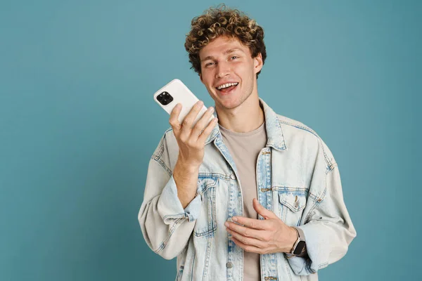 Młody Kręcone Człowiek Nosić Dżinsową Kurtkę Rozmowy Telefon Komórkowy Odizolowany — Zdjęcie stockowe