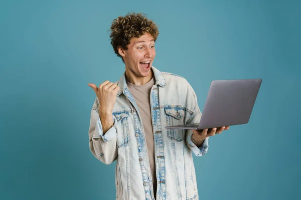 Νεαρός Ενθουσιασμένος Άντρας Που Χρησιμοποιεί Φορητό Υπολογιστή Ενώ Δείχνει Δάχτυλο — Φωτογραφία Αρχείου