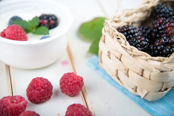Buah berry segar dalam keranjang di atas meja kayu — Stok Foto