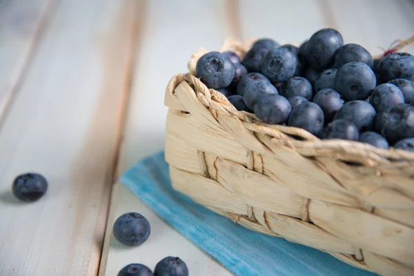 Fresh blueberries in basket on kitchen table — Stock Photo, Image