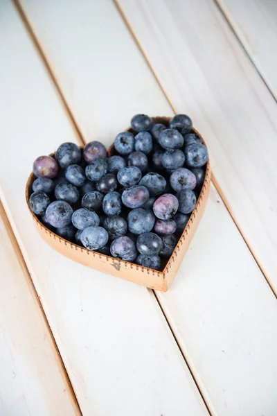 Čerstvé borůvky srdce tvar koše na kuchyňském stole — Stock fotografie