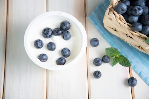 Fresh blueberries in basket on kitchen table — Stock Photo, Image