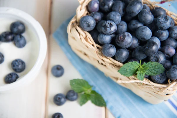 Fresh blueberries in basket on kitchen table — Stock Photo, Image