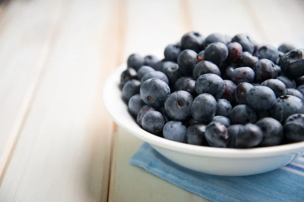 Fresh blueberries ion white plate on kitchen table — Stock Photo, Image