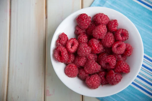 Verse frambozen op plaat op keukentafel — Stockfoto