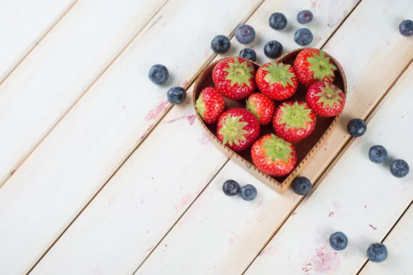 Frische Erdbeeren und Blaubeeren in Herzform Korb auf Bausatz — Stockfoto