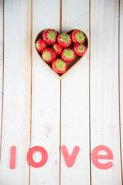 Fresas frescas en forma de corazón cesta en la mesa de la cocina — Foto de Stock