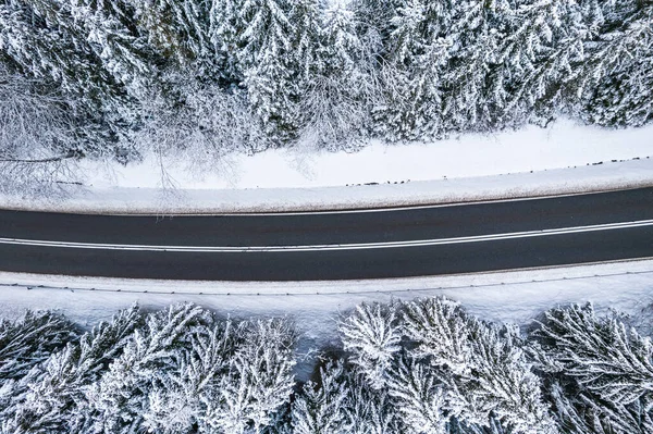 Winter Road in Snowy Forest. Top Down Drone Aerial view.