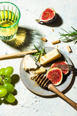 Cheese Appetizer with Figs and Grapes on Table.