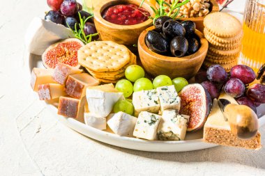 Tasty Appetizer Cheese Board with Various Food on Platter.