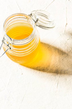 Honey Jar in Bright Light on Concrete Background.