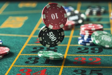 Casino Chips Flying Over Roulette Green Table.