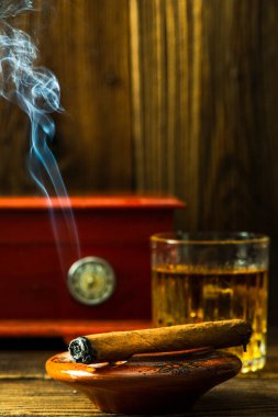 Cuban Cigar Smoking in Ashtray on Wooden Table.
