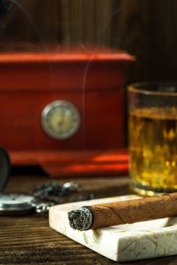 Smoking Cuban Cigar. Tobacco and Humidor on Wooden Table.
