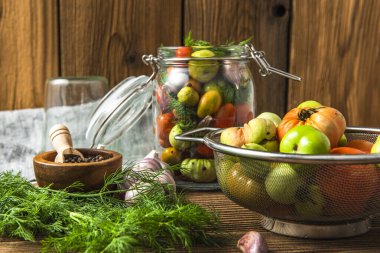 Pickled Tomatoes in Jar with Herbs. Healthy Preserved Food.