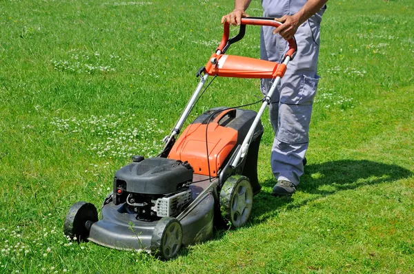 Trabajador de césped en movimiento en el prado — Foto de Stock