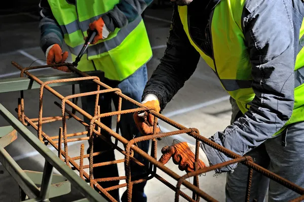 Primer plano en las manos de fijación de barras de refuerzo de acero Fotos de stock