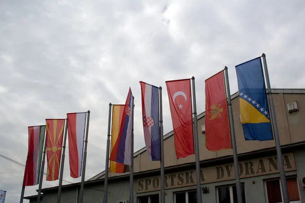 LUKAVAC, BOSNIA Y HERZEGOVINA - 8 DE MAYO DE 2014: Banderas frente a feria turística — Foto de Stock