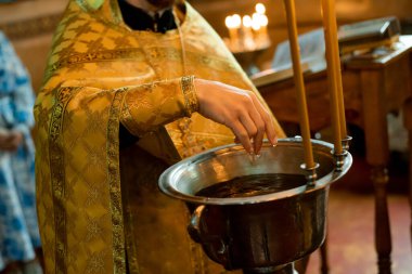 Bir rahibin ellerine bir kase suyla yakın çekim.