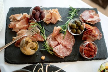Farklı aperatifler antipasti, şarküteri, aperatifler ve kırmızı şarap. Açık büfe partisi için sosis, jambon, tapas, zeytin ve kraker. Üst manzara, düz uzanma