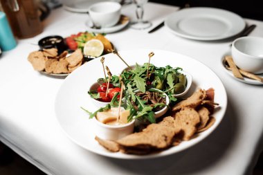 assorted cheese, olives, tomato and croutons on a plate