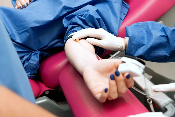 medical procedure, the doctor takes blood from the patient's vein, close-up