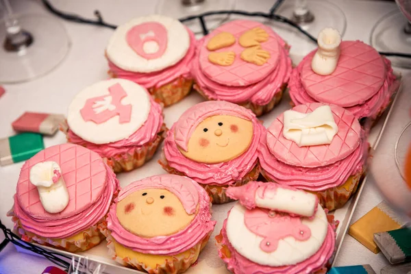 pink cupcakes with drawings on top