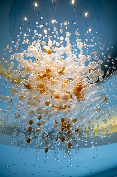 Lambadaki avizenin üzerindeki ışık topları tavandan sarkan ampuller, arka plandaki lambalar. Seçici odak, yatay, hiç kimse