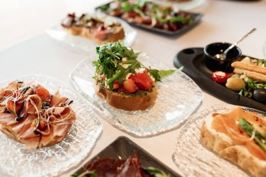 bruschetta square set top view. Brushetta set for wine. Variety of small sandwiches with prosciutto, tomatoes, cheese, herbs