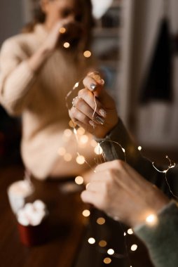 close-up of a girl's hands with a christmas garland