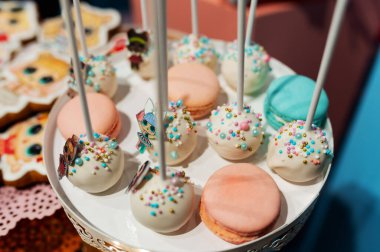 colorful round candies on sticks and macaroons